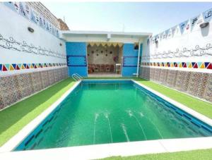 阿斯旺Bakar House的一座绿色的游泳池,位于一座建筑中