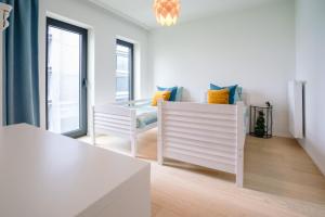 奥斯坦德Vakantieappartement Oosteroever Oostende的白色的客房配有桌子和两把椅子