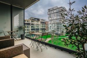 奥斯坦德Vakantieappartement Oosteroever Oostende的一个带桌椅的阳台和一座建筑
