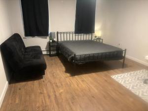 波士顿3 HOMESTAY At Boston In Dorchester or JFK-UMASS or South Boston的一间卧室配有一张床和一张黑椅