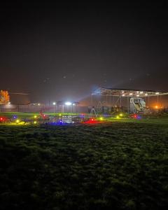Al WafrahGamarah farm的夜间足球场,背景是一座建筑