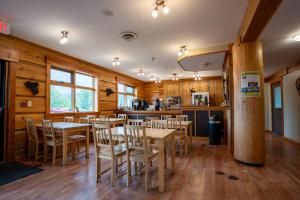 戈尔登Basecamp Lodge Golden的餐厅拥有木墙和桌椅
