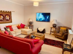 沃明斯特Large historic family home nr Longleat and Bath的客厅配有红色的沙发和椅子