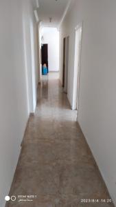 马特鲁港Luxry flat in matrouh的长长的走廊,有白色的墙壁和地板