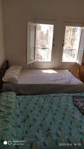 马特鲁港Luxry flat in matrouh的窗户和床单的客房内的一张床位