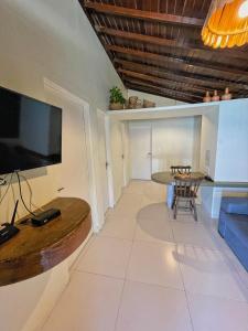 科鲁里皮Pousada Paradise的客厅配有大电视和桌子
