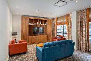 蒙特利尔Hôtel 2170 Lincoln Downtown Montreal的客厅配有2张蓝色沙发和电视