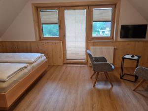 TurnauRomantik Chalet Pretalhof的一间卧室配有一张床、一把椅子和窗户。