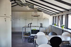 格林斯泰兹Danhostel Grindsted-Billund的厨房配有白色橱柜和白色的桌椅