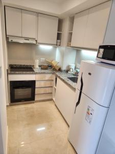 波萨达斯Costanera Vista的厨房配有白色橱柜和白色冰箱。