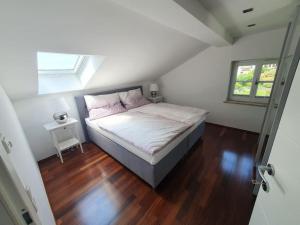 马特塞Moderne Ferienwohnung Bestlage in Mattsee Salzburg Salzburger Seenland Urlaub am See的一间卧室配有一张床,铺有木地板