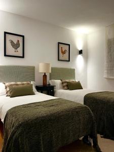 Cerezo de ArribaApartamento LOS CORZOS - LA PINILLA的酒店客房,设有两张床和一盏灯