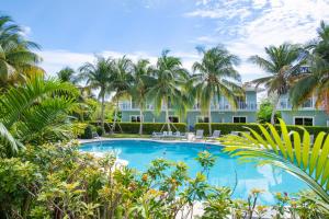 西湾Summertime Suites #49的棕榈树建筑前的游泳池