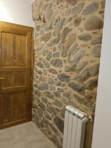 佩夏Casa in Bocca al Fiume的石墙,带门和散热器