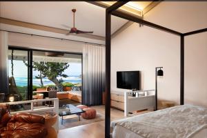 卡胡库Ocean Bungalows at Turtle Bay Resort的一间带吊扇的卧室和一间客厅