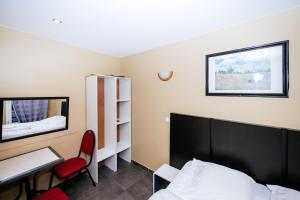 巴黎德拉波斯特酒店的一间卧室配有一张床、一张书桌和一面镜子