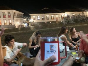 欧鲁普雷图La Musica Hostel OuroPreto的一群人晚上坐在桌子旁