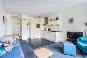 阿姆斯特尔芬Newa 1的一间带蓝色沙发的客厅和一间厨房