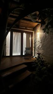 TaipuMAYIM VILLA的一间位于木甲板上的带椅子的黑暗客房