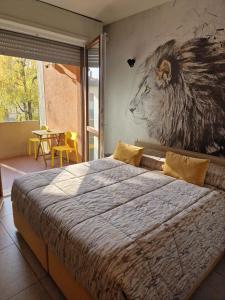 塞里亚泰Nyx Lilura Foresteria Lombarda的卧室配有一张大床,墙上挂有狮子画