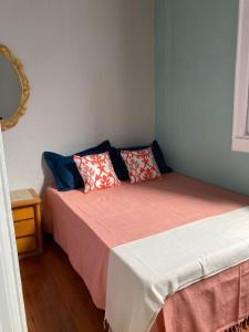 尤西德福拉Pousada Barão de Santa Helena的一间卧室配有两张带红色和蓝色枕头的床