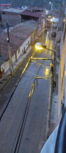瓦拉斯Villa hospedaje的一条空的街道,晚上有火车轨道和灯