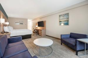 阿什兰河城贝斯特韦斯特酒店的酒店客房配有床、沙发和桌子。