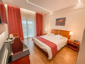 普拉奇里奥塞萨洛尼基国宾大酒店的酒店客房设有床和窗户。