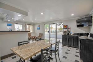 圣贝纳迪诺Studio 6 Suites San Bernardino, CA的厨房配有桌椅和柜台。