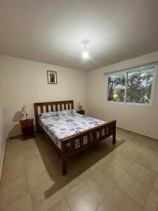 多洛雷斯镇Cabaña La Huerta "Traslasierra"的一间带木床的卧室,位于带窗户的房间内