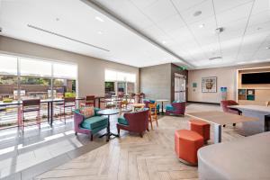 圣贝纳迪诺Home2 Suites By Hilton San Bernardino的用餐室设有桌椅和窗户。