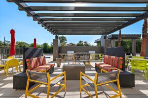 圣贝纳迪诺Home2 Suites By Hilton San Bernardino的庭院设有色彩缤纷的椅子和火坑