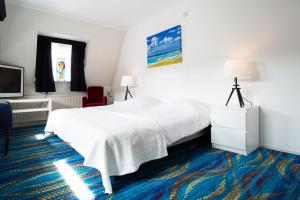 奥特马瑟姆Hotel Van der Maas的酒店客房设有白色的床和电视。