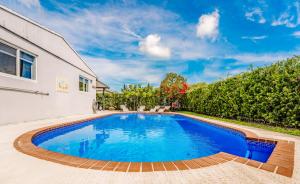 劳德代尔堡Home with heated pool close to beach and FLL airport的一座房子后院的游泳池