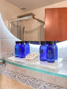 普拉奇里奥塞萨洛尼基国宾大酒店的浴室内架子上一组蓝色瓶子