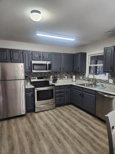 布什基尔Poconos Retreat的厨房配有黑色橱柜和不锈钢用具