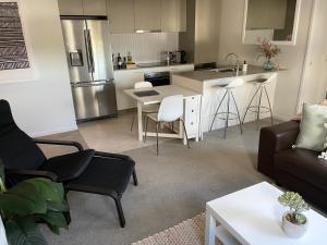 TuggeranongBlackdiamond 504 - Beautiful, modern apartment - 2BdR, 2BthR的带沙发的客厅和厨房