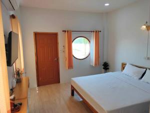Ban Mae Laiกุหลาบแก้ว รีสอร์ท的一间卧室设有一张大床和一扇红色的门