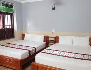 潘郎Khách sạn Ánh Đông的两张床位于带窗户的房间内