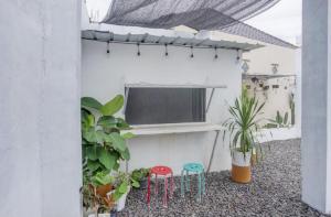 班达楠榜Oemah Ratu Hostel Syariah RedPartner的阳台设有2张凳子,墙上设有电视