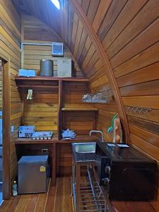 拉威海滩Seaview Eagles Nest Cabins的带木墙的客房内设有带水槽的厨房