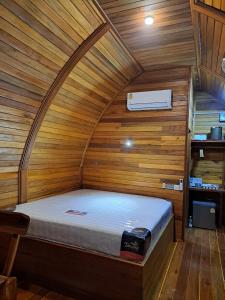 拉威海滩Seaview Eagles Nest Cabins的木墙客房的一张床位