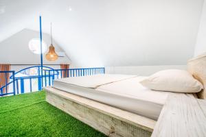 DarmasabaAnny Guesthouse by ecommerceloka的绿草间的一张床