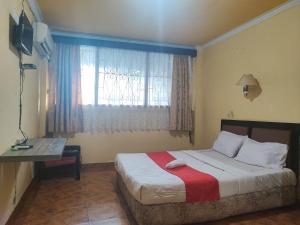 占碑市RedDoorz Syariah At Hotel Matahari 1 Jambi的一间卧室设有一张大床和窗户