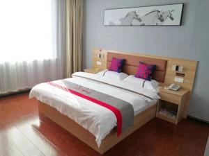 Tung-ts'un-chenJun Hotel Shanxi Lvliang Lan County Bus Terminal的一间卧室配有一张大床,铺有红白毯子