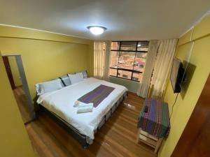 瓦拉斯Wayra Hotel的一间卧室设有一张大床和一个窗户。