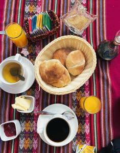 瓦拉斯Wayra Hotel的一张桌子,上面放着一篮面包和一杯咖啡