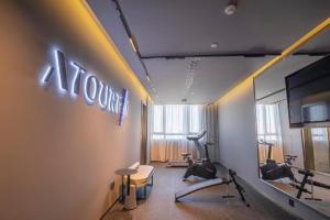 滨海新区Atour Hotel Tianjin Shengtaicheng Maritime Museum的健身房设有健身器材和墙上的标志