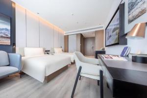 济南Atour Hotel Jinan Tangyan Dongbaqu Enterprise Park的酒店客房配有两张床和一张书桌