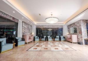 Al KhānALAZMI HOTEL的大堂设有桌椅和吊灯。